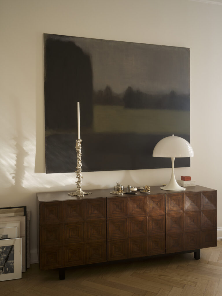 Målningen är av Martin Ålund, skåpet från Dusty Deco, lampan är designad av Verner Panton och ljusstaken är från Polspotten.