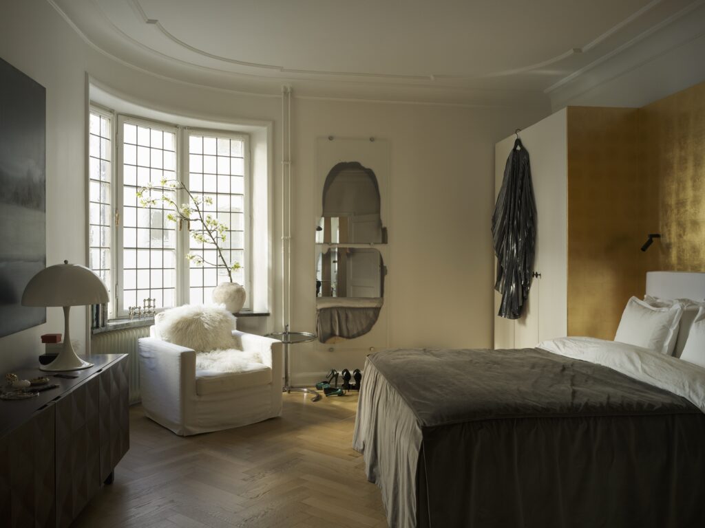 Sovrumsväggen är gjord av bladguld. Spegeln är designad av Jenny Nordberg och lampan av Verner Panton.
